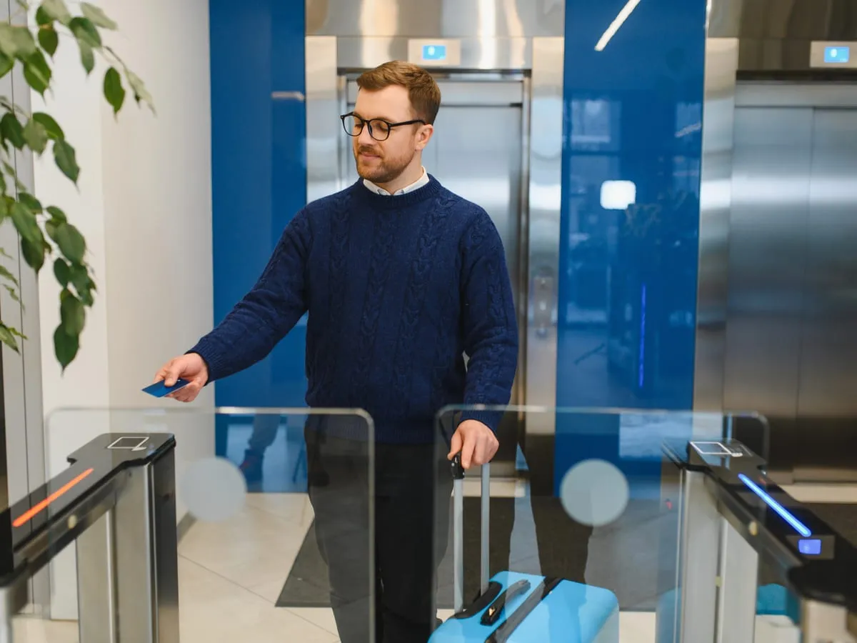 Person badging through a secured speed-gate in a commercial building lobby